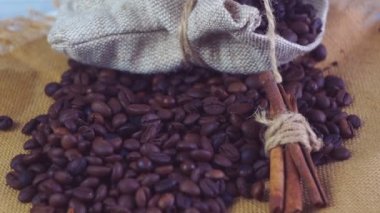 Kahve ve kahve çekirdekleri. Beyaz fincan kahve kavrulmuş fasulye ile masada uçucu.