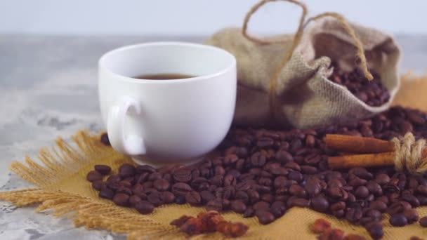Šálek kávy a kávových zrn. Bílý hrnek odpařovací kávu na stůl s pečené fazole.