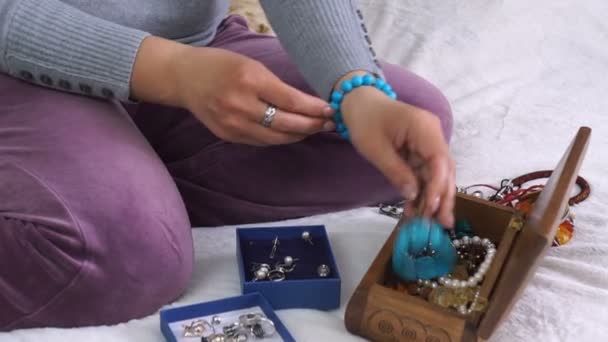 Close Van Handen Van Vrouw Gelijkmakende String Met Parels Armband — Stockvideo