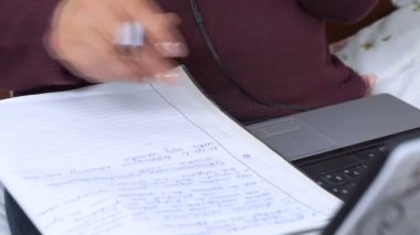 İş kadını closeup kalem içinde a defter, laptop klavye yazıyor..