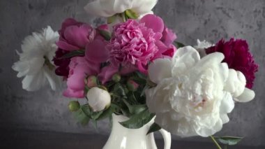 Cam vazo içinde sunulan renkli şakayık buket. Taze bahçe peonies.