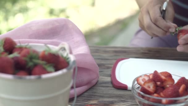 女性の屋外ボード デザートにイチゴをスライス — ストック動画