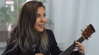 Genç kız evde akustik gitar çalmak