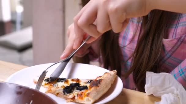 一个女孩在咖啡馆里吃比萨饼 手里拿着食物 — 图库视频影像