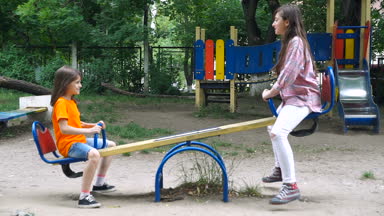 Mutlu çocuklar yaz Park'ta bir salıncak üzerinde binmek.