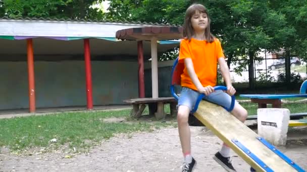 Ευτυχισμένα παιδιά δύο βόλτα σε μια ταλάντευση στο πάρκο καλοκαίρι. — Αρχείο Βίντεο