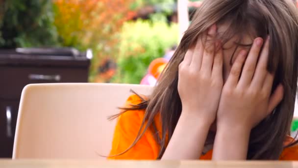 Little girl covers her face with hands. — Stock Video