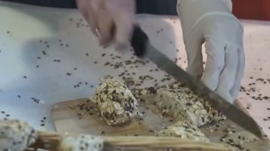 Kadın ekmek kesme tahtası üzerinde keser.