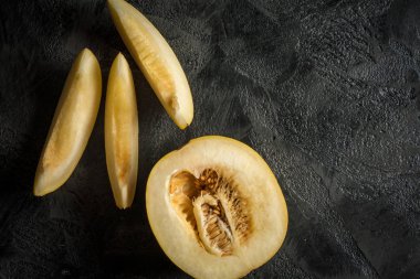 Taş masanın üzerine dilimlenmiş tatlı sarı mwlon