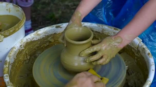 陶工の手が粘土からカップを形します 陶芸ろくろで陶器を作成するプロセス マスター陶芸家は 彼のスタジオで鍋をする生徒を教えています 手だけクローズ アップ — ストック動画