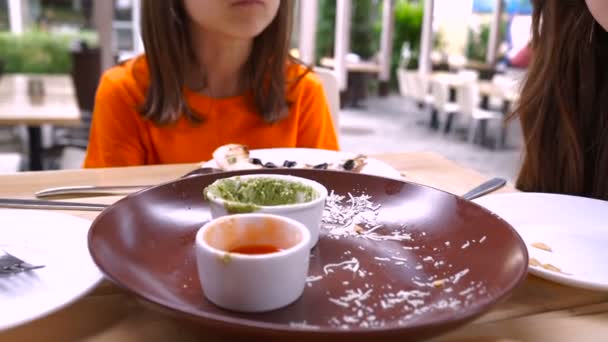 Δύο μικρά κορίτσια τρώνε σε ένα γρήγορο φαγητό καφέ. — Αρχείο Βίντεο