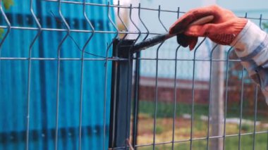 Siyah boya ile demir çitleri boyamak işçi