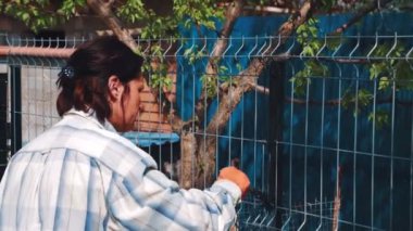 Siyah boya ile demir çitleri boyamak işçi