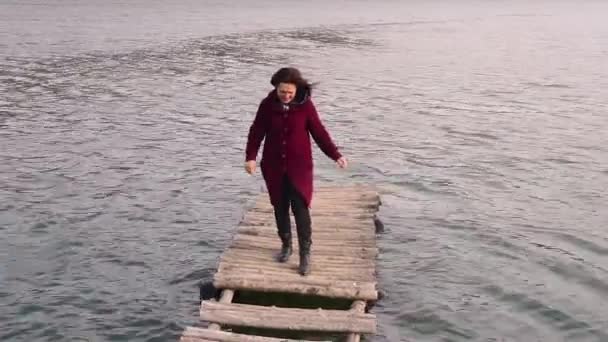 女性は川の古い橋を渡る — ストック動画