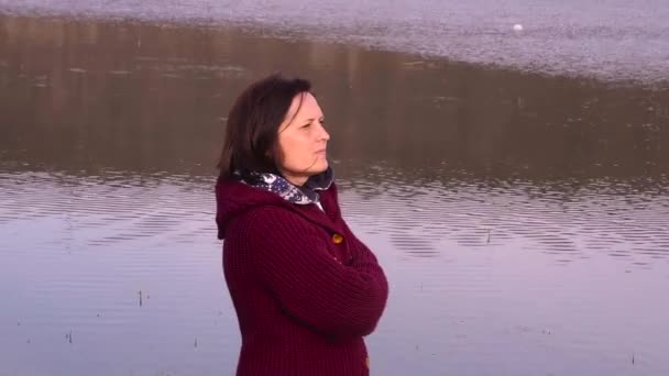若い女性が川を背景にポーズの肖像画を間近します — ストック動画