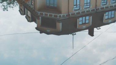 Yansıma yağmur su birikintisi üzerinde bina. Sokakta yağmur suyu yansımalar