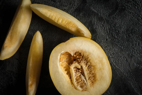 Taş masanın üzerine dilimlenmiş tatlı sarı mwlon