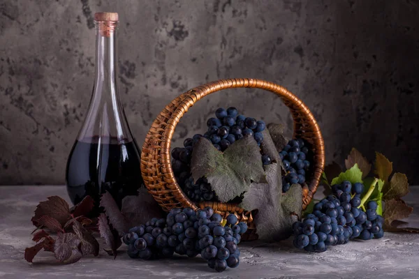 バスケットとワインのボトルの赤葡萄のある静物 — ストック写真