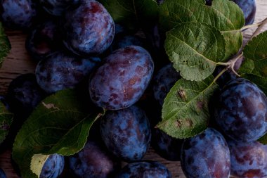 Ahşap masa yapraklarda ile taze erik. Doğal gıda.