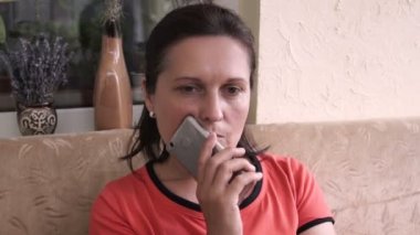 Terasta oturan smartphone kullanan mutlu genç kadın.