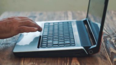 Adam parmak klavye dizüstü bilgisayar kaydediyor. Smartphone kullanır. Yakın çekim.