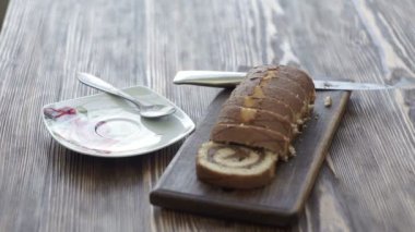 Sabah bir bitkisel çay ve kek tadımı yakın çekim. Adam beyaz bir bardaktan bir içecek içme ve evde bir tatlı yemek.