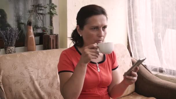 テラスでコーヒー Ing のスマート フォンを飲む女性 — ストック動画