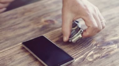 Adam tablo ahşap yüzey nöbeti alıyorum. Soyunma. adam telefonu masanın üzerine alır.