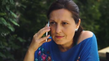 Bahçe ve cep telefonu üzerinde sohbet kafede oturan güzel kadın