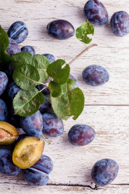 Ahşap masa yapraklarda ile taze erik. Doğal gıda.