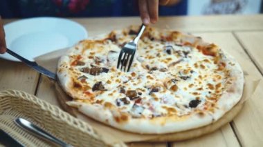 esmer kadın bir kafede lezzetli pizza yiyor.