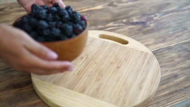 Mano Mujer Poner Tazón Con Moras Mesa Madera — Vídeo de stock