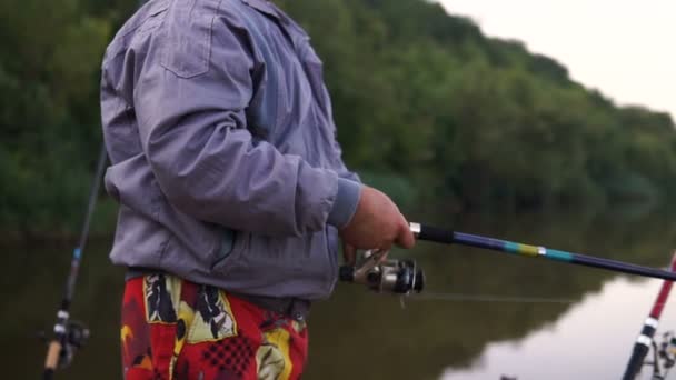 釣り竿と漁師 回転棒を押しながらねじりコイルの手のクローズ アップ — ストック動画