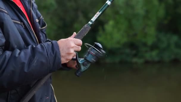 Fiskare Med Ett Fiskespö Närbild Hand Hålla Haspelspö Och Vrida — Stockvideo