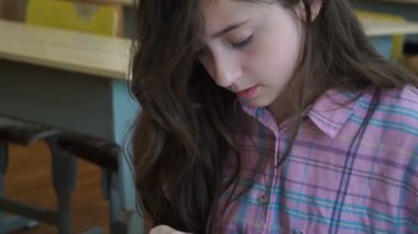 renkli modelleme hamuru odasında yapılmış küçük kız masa başında oturan farklı rakamları sculpts.