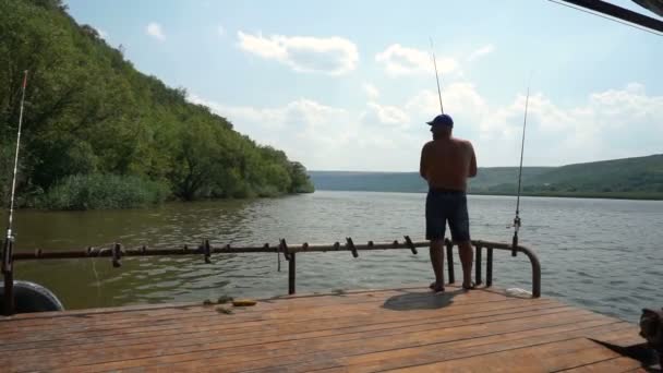 在河里钓鱼 Deckof 船上河上钓鱼竿的渔夫 — 图库视频影像