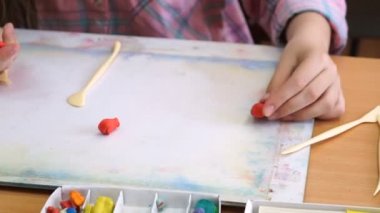 küçük kız masa başında oturan bir farklı rakamlar sculpts