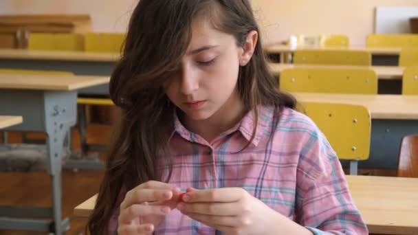 Little girl sitting at the desk sculpts a different figures — Stock Video