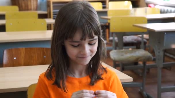 Petite fille assise au bureau sculpte des figures différentes — Video