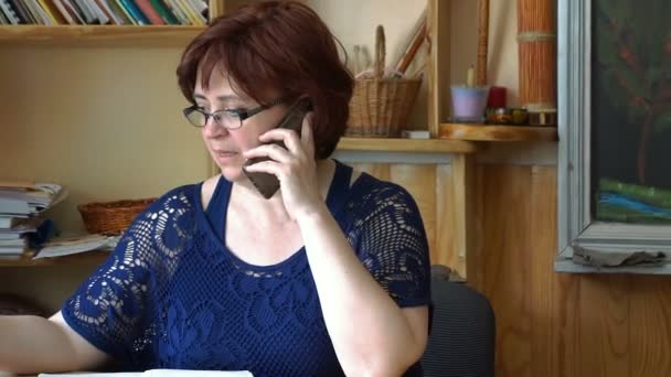 Glimlachende zakenvrouw bellen op telefoon in kantoor — Stockvideo