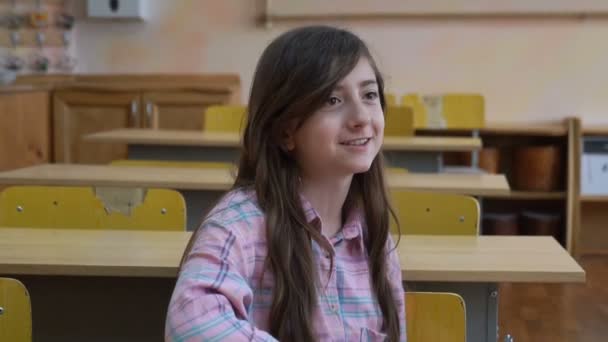 十几岁的女孩 高中学生微笑着坐在教室里的相机 — 图库视频影像