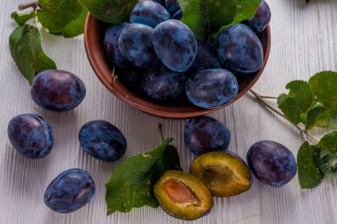 Ahşap masa üzerinde kase taze erik. Doğal gıda.