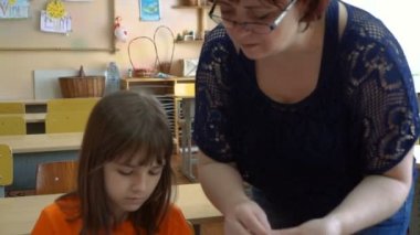 Bir öğretmen ve dört çocuk. öğretmen öğrencilere model hamuru öğretir