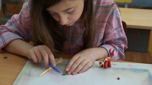 Mała Dziewczynka Siedzi Przy Biurku Rzeźbi Różnych Figur Wykonane Kolorowych — Wideo stockowe