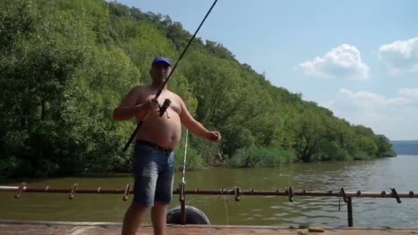 川での釣り Deckof ボートに乗って川の釣り竿を持つ漁師 — ストック動画