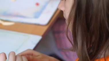 renkli modelleme hamuru odasında yapılmış küçük kız masa başında oturan farklı rakamları sculpts.