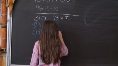 Genç öğrenci tahtaya karmaşık matematiksel formül denklem yazma.