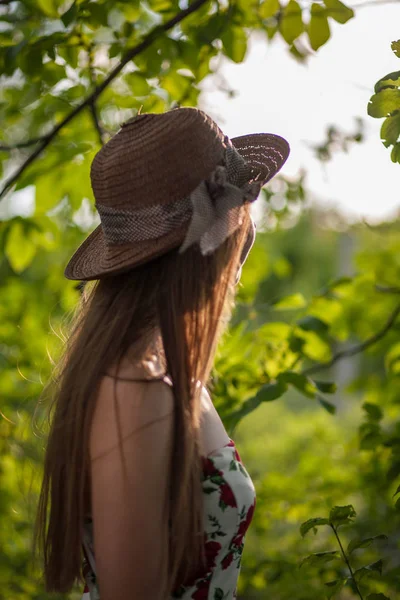 一个美丽优雅的女人在白色的礼服和帽子站在夏季公园的肖像 — 图库照片