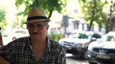 Kameraya bakarak ve gülümseyen Gözlüklü olgun, çekici bir adam portresi.