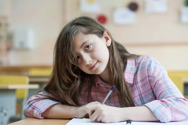 Kleines Mädchen Schreibt Etwas Ins Textbuch Und Sitzt Tisch — Stockfoto